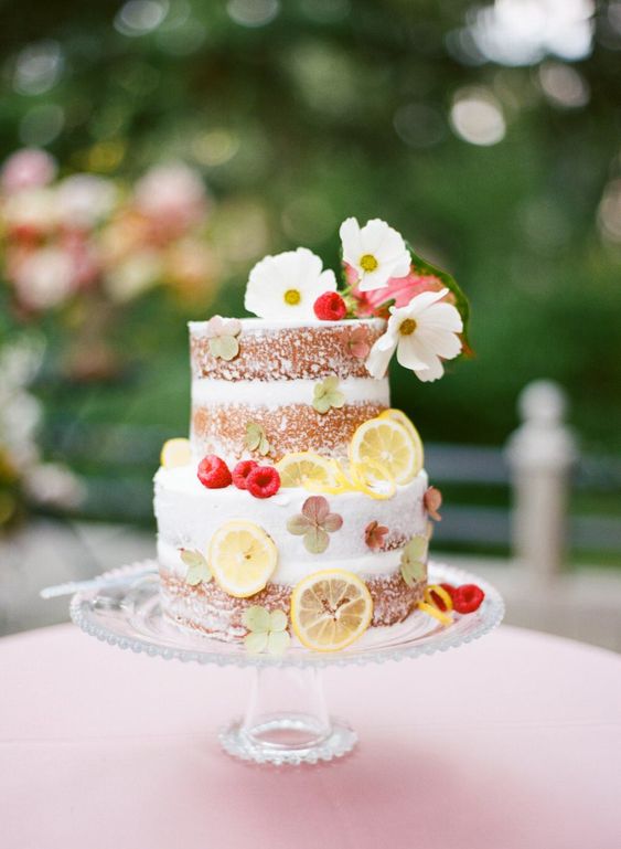 a fun naked wedding cake decorated with greeneyr, white blooms and citrus slices will do for a summer wedding, too