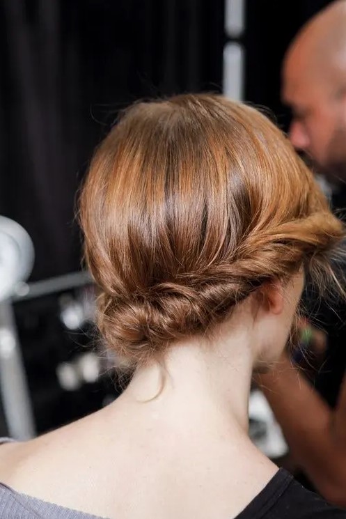 a low twisted updo with a sleek top and a bit of texture is a cool idea for medium length hair, it looks chic