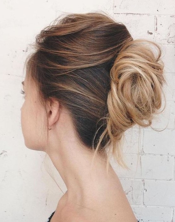 a messy and chic French twist chignon with a messy and layered top and a messy low bun