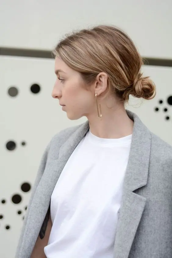a messy low bun with a textured volume on top is a fast and cool idea for a modern or casual wedding