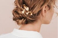 a messy twisted low bun and waves on top plus waves on the front and some floral hair pins is a cool idea
