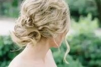 a messy wavy and twisted updo for an effortlessly chic bride, such an updo cna be worn with long or medium length hair