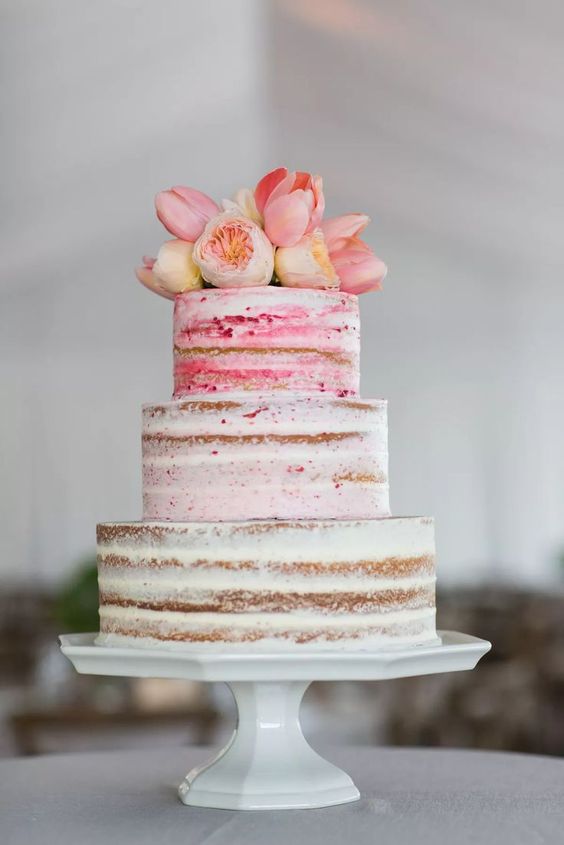 a naked wedding cake topped with fresh tulips and peony roses is a cool idea for spring and summer