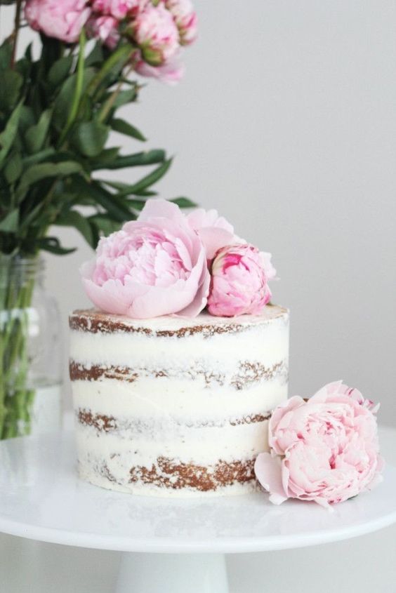 a naked wedding cake with pink peonies on top is all you need for a relaxed spring wedding