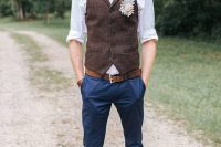 a simple rustic groom’s look with a white shirt, navy pants, a brown woolen waistcoat, a brown belt and shoes
