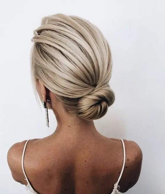 a sleek low bun with a bump is a cool idea is a great option for a minimalist or modern wedding