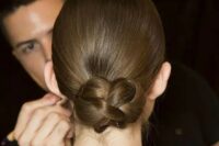a sleek low updo with a braided bun is a cool and modern interpretation of a traditional low bun or chignon