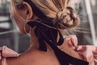 a small braided low bun with a bit of volume on top accented with a black velvet ribbon and a bow is a lovely and girlish idea