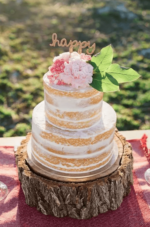 a spring or summer naked wedding cake with pink and blush blooms and leaves is a cool idea