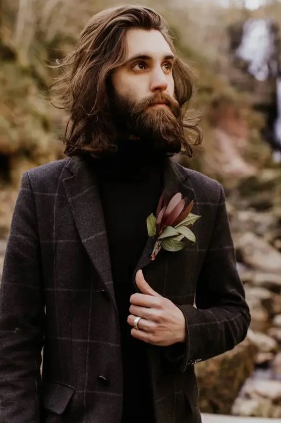 a stylish and dramatic fall groom's outfit with a brown windowpane suit, a black turtleneck and a moody boutonniere is cool