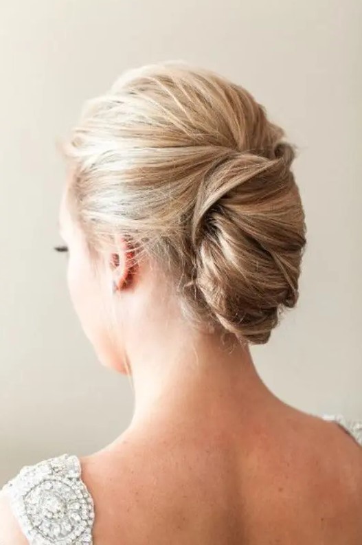 a tight French twist updo with a volume on top on balayage hair for a chic and stylish look