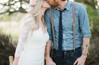 a very relaxed and rustic groom’s outfit with navy jeans, a blue chambray shirt, a navy tie, suspenders and a cap