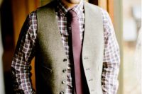 a very relaxed rustic groom’s look with brown pants, a plaid shirt, a purple tie and a grey waistcoat