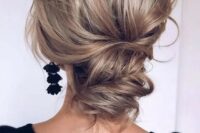 a wavy and chic low updo with a volume on top and some waves is a cool option for a modern refined look