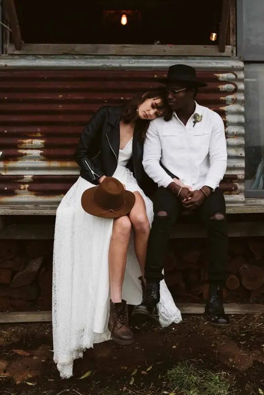 a white shirtjacket, black ripped jeans, black combat boots and a black hat are a lovely and cool outfit for a fall wedding