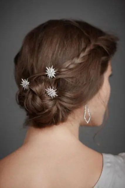 a woven and braided low bun with braids on the sides and celestial hair pins is a dreamy and chic solution for a wedding