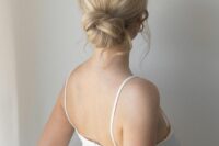 a woven low bun wiht a sleek yet dimensional top and waves down is a stylish and elegant idea for a wedding