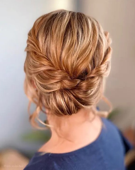an elegant low updo with a braided halo and a low bun plus some volume on top is a cool and chic idea