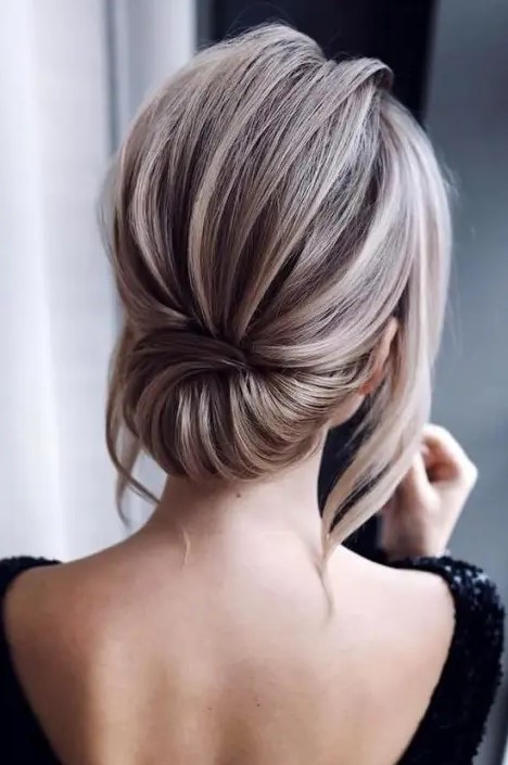 an elegant low updo with a dimensional bump and locks down is a stylish modern hairstyle