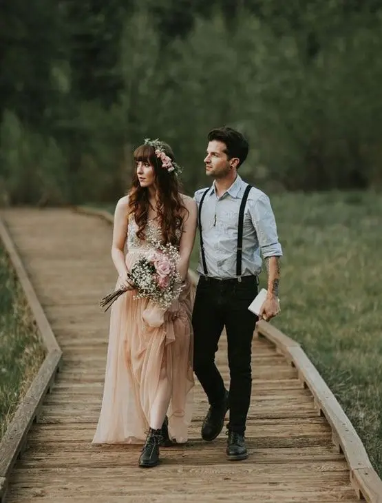 an informal meets boho groom's look with a light blue shirt, black jeans and suspenders and black shoes