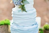02 a buttercream ombre blue wedding cake with alarge succulent on top and some greenery