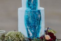 02 a watercolor blue wedding cake with a bold blue detail and some metallic touches plus bold blooms on top