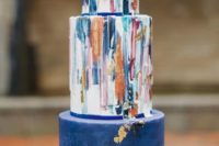 04 a bright watercolor wedding cake with a navy and gold leaf tier looks like an impressionist’s artwork