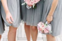 04 bridesmaids wearing grey strapless dresses and carrying blus rose bouquets