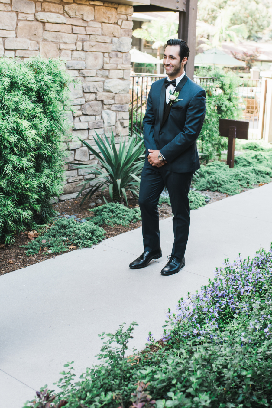 The groom was wearign a navy suit with black lapels and a bow tie
