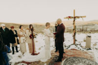 07 The ceremony space was covered with boho rugs, there was a large cross with greenery and blooms