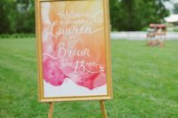 07 a bright watercolor orange and pink wedding sign in a frame for a summer wedding