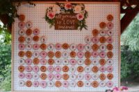 07 a framed pegboard donut wall topped with fresh blooms and a sign