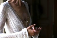 07 a heavily embellished lace applique wedding dress with bell sleeves and a nude buttoned bodice