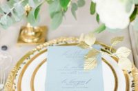 07 an exquisite wedding tablescape with blue florals, a gold edge plates and chargers plus gold candle holders