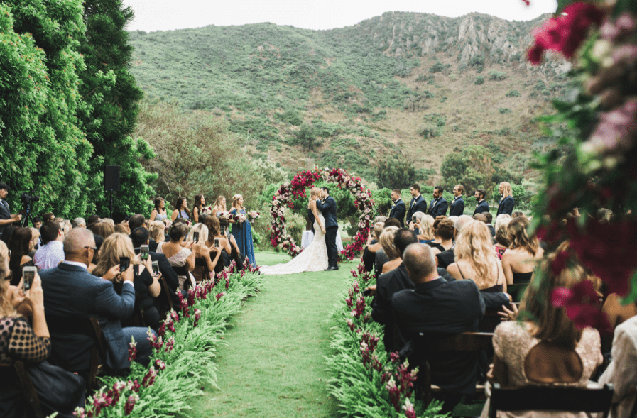 The aisle was also decorated with greenery and jewel tone blooms