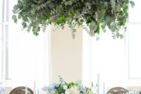 08 a dramatical leafy chandelier draped with eucalyptus and camellia foliage is a showpiece