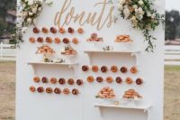 08 an elegant outdoor donut wall with shelves, calligraphy and fresh blooms for a chic wedding