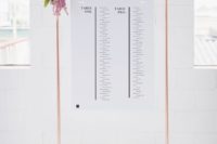 09 a copper frame with black and white seating charts and fresh blooms