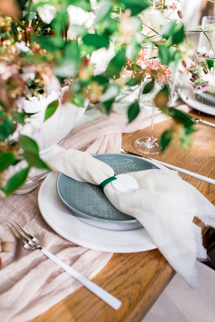 The table was decorated with lush florals, a blush runner and ivory napkins, green plates and neutral chargers