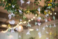 10 a pretty greenery and bloom chandeleir with pastel paper cranes for decorating the venue