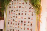 11 a chic framed donut wall with lush greenery and blooms looks liek a tasty artwork