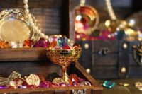 11 a simple treasure chest centerpiece can be DIYed of some bold rhinestones, pearls and faux gold goblets