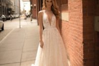 11 a sparkling deep plunging neckline wedding dress with a train and straps by Berta