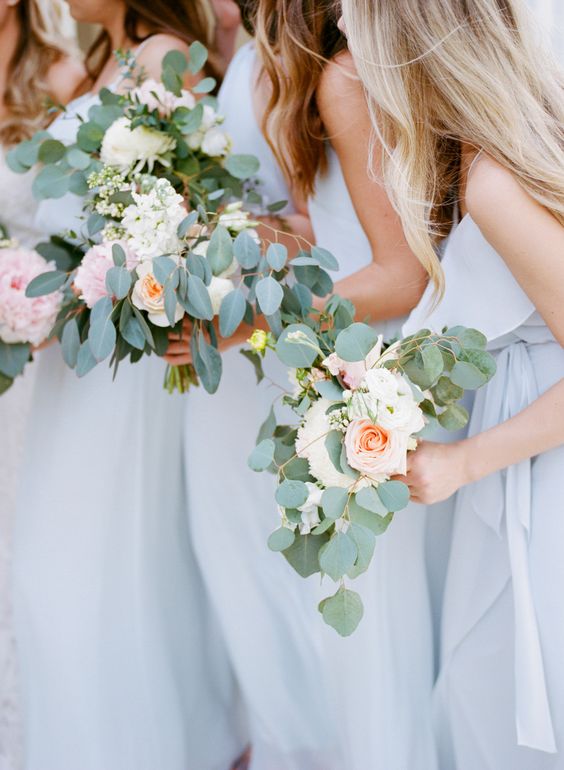 bridesmaids wearing light blue dresses with blush bloom bouquets