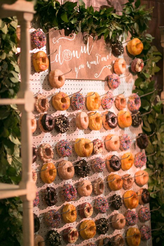 a pegboard donut wall decorated with fresh greenery garlands