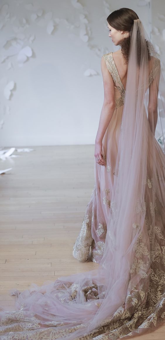 a bride rocking a pink and gold lace wedding gown and a pink veil