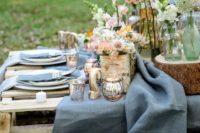 14 a garden picnic setting with muted tone textiles, pallet tables, lush blooms and some rustic touches