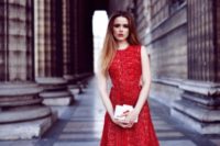 16 a sleeveless red lace midi dress, nude spiked heels and a white geometric clutch