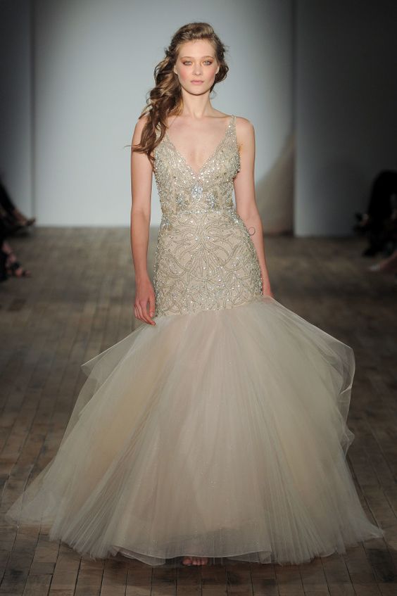 a champagne colored heavily embellished wedding dress with a tail and an embroidered bodice on straps by Lazaro