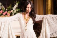 17 a gypsy-inspired wedding dress with a deep V-neckline, bell sleeves and embellishments